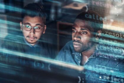 Concept of two young professional men looking at a screen in a technological data centre