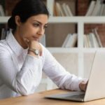 Smart young brown businesswoman working from home on a laptop