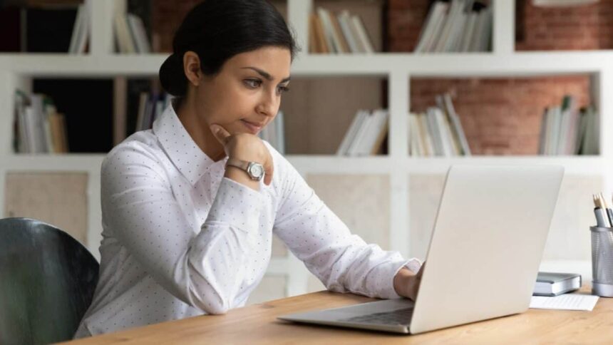 Smart young brown businesswoman working from home on a laptop