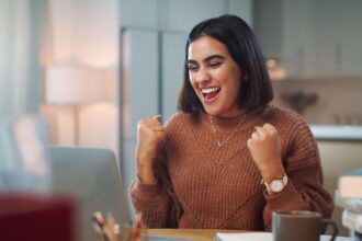 Young brown woman delighted with what she sees on her screen