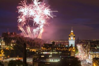 Edinburgh Cityscape with fireworks over The Castle and Balmoral Clock Tower