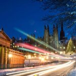 Light trails from traffic moving down The Mound in central Edinburgh, Scotland during December